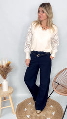 Pull fin en maille 75% viscose, col V, couleur [préciser la couleur : ex: taupe/beige], porté rentré dans un pantalon foncé.