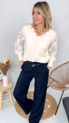 Pull fin en maille 75% viscose, col V, couleur [préciser la couleur : ex: taupe/beige], porté rentré dans un pantalon foncé.