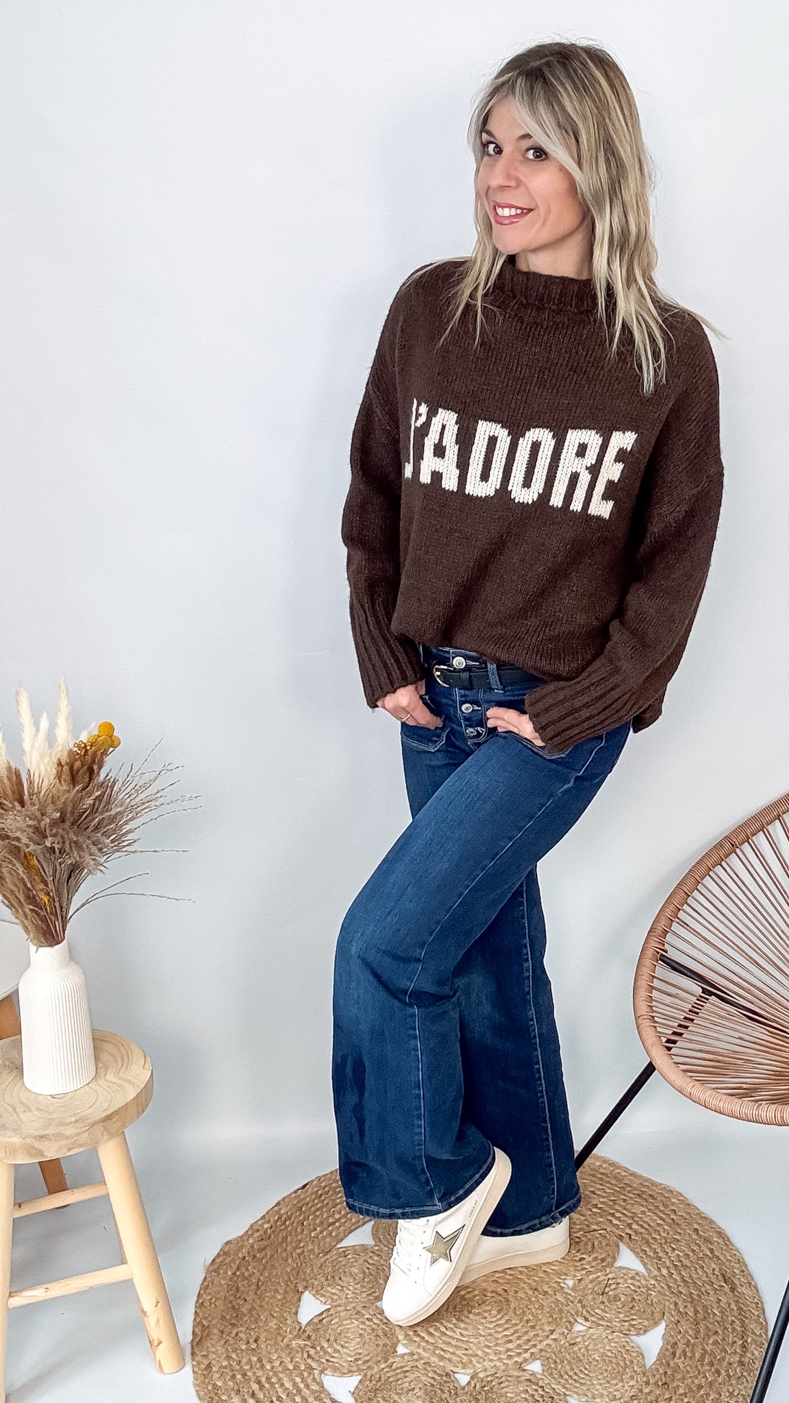 Pull marron col roulé maille, fabriqué en Italie, porté rentré dans un pantalon foncé.