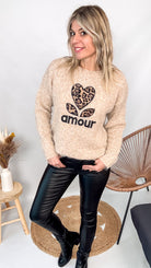 Pull oversize beige/taupe en maille mélangée (laine), coupe ample, porté rentré avec un pantalon foncé