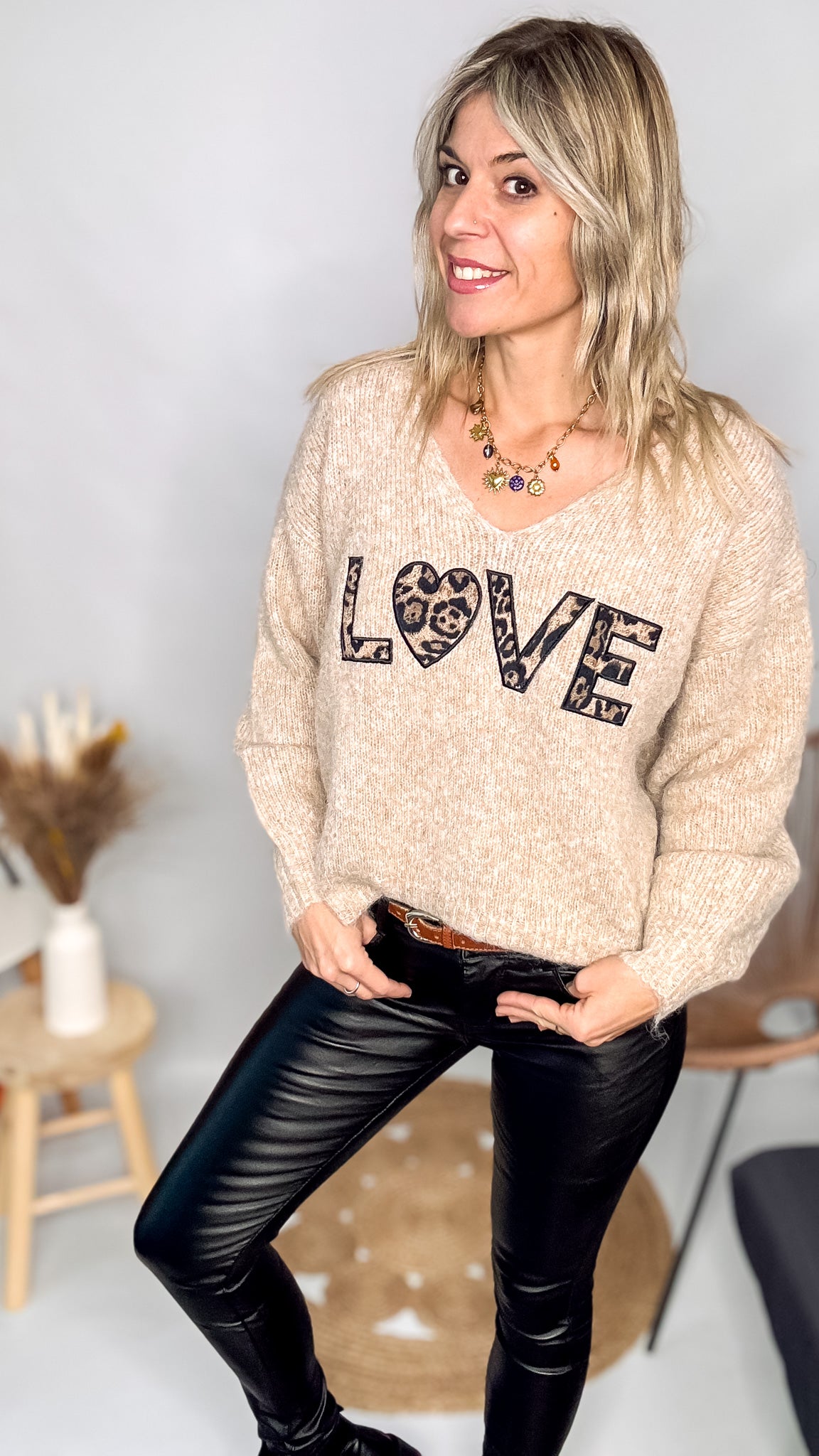 Pull oversize col V beige/taupe en maille douce (laine), porté rentré avec un pantalon foncé