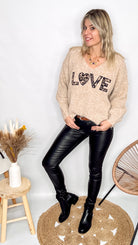 Pull oversize col V beige/taupe en maille douce (laine), porté rentré avec un pantalon foncé