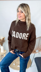 Pull marron col roulé maille, fabriqué en Italie, porté rentré dans un pantalon foncé.